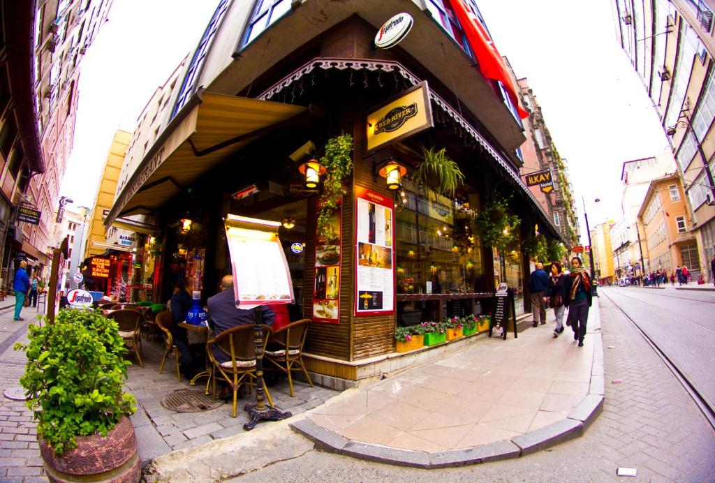 una tienda en una calle con gente sentada fuera de ella en Ilkay Hotel en Estambul