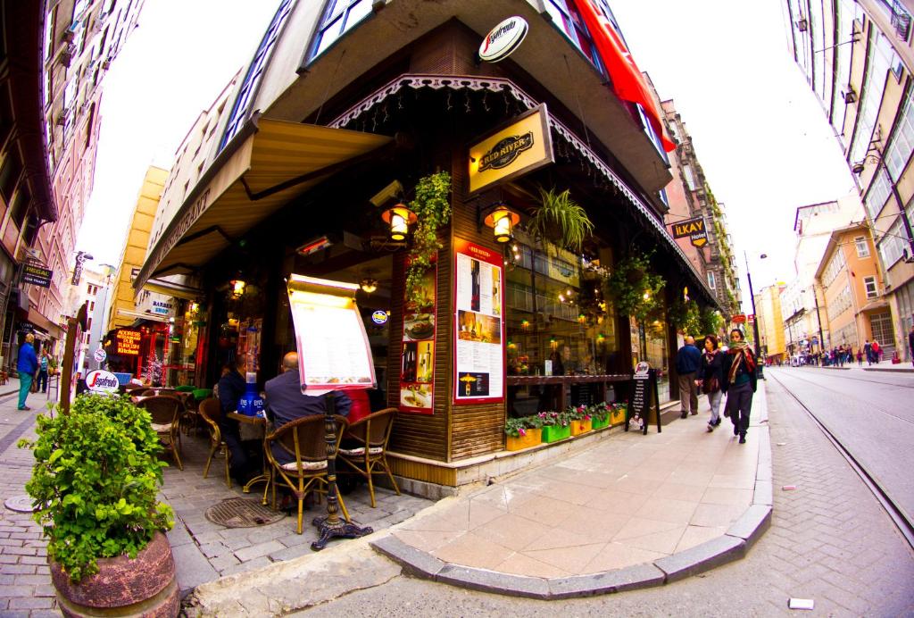 a store on a street with people sitting outside of it at Ilkay Hotel in Istanbul