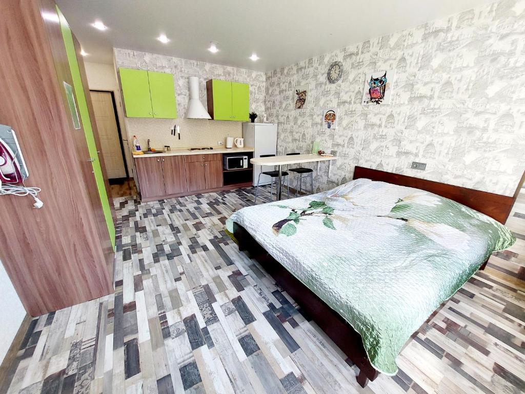 a bedroom with a large bed and a kitchen at Апартаменты СВ "Атлант" in Tver