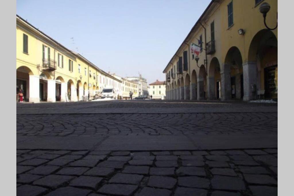 a cobblestone street in a town with buildings at Rocks Appartamenti i Portici nel centro storico! in Melzo