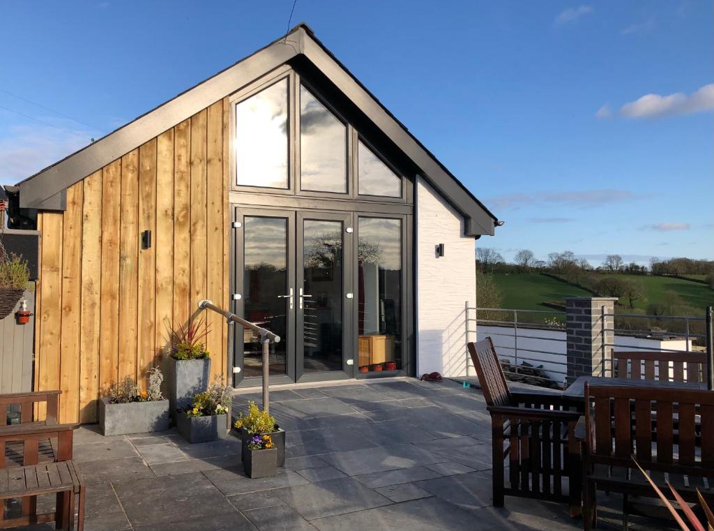 a house with glass doors on a patio at Red Kite Cottage in Carmarthen