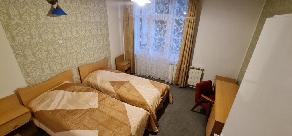 a hotel room with two beds and a window at Kasztelanka in Krynica Zdrój