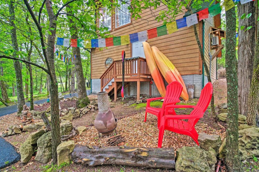 a house with two red chairs and a surfboard at Bright Lakeside Studio - Hike, Fish, and Bike! in Golden