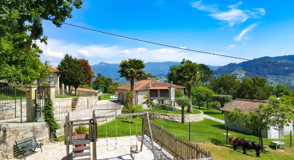 a house with a fence and a cow in a yard at Quinta da Toural in Arcos de Valdevez