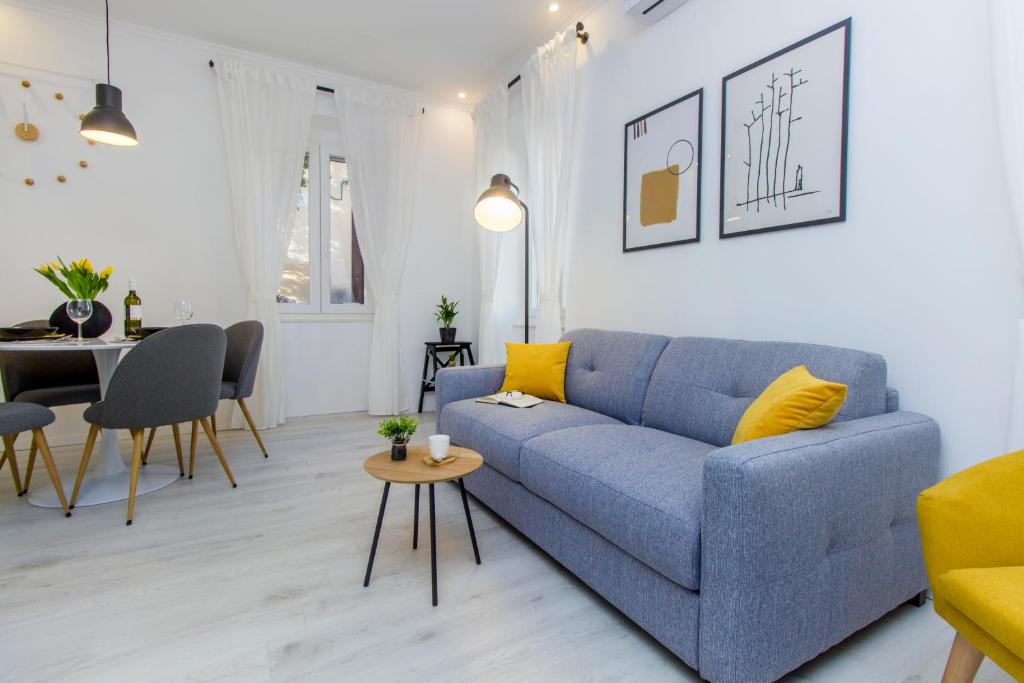 a living room with a blue couch and a table at Apartment Ena ,city center in Šibenik