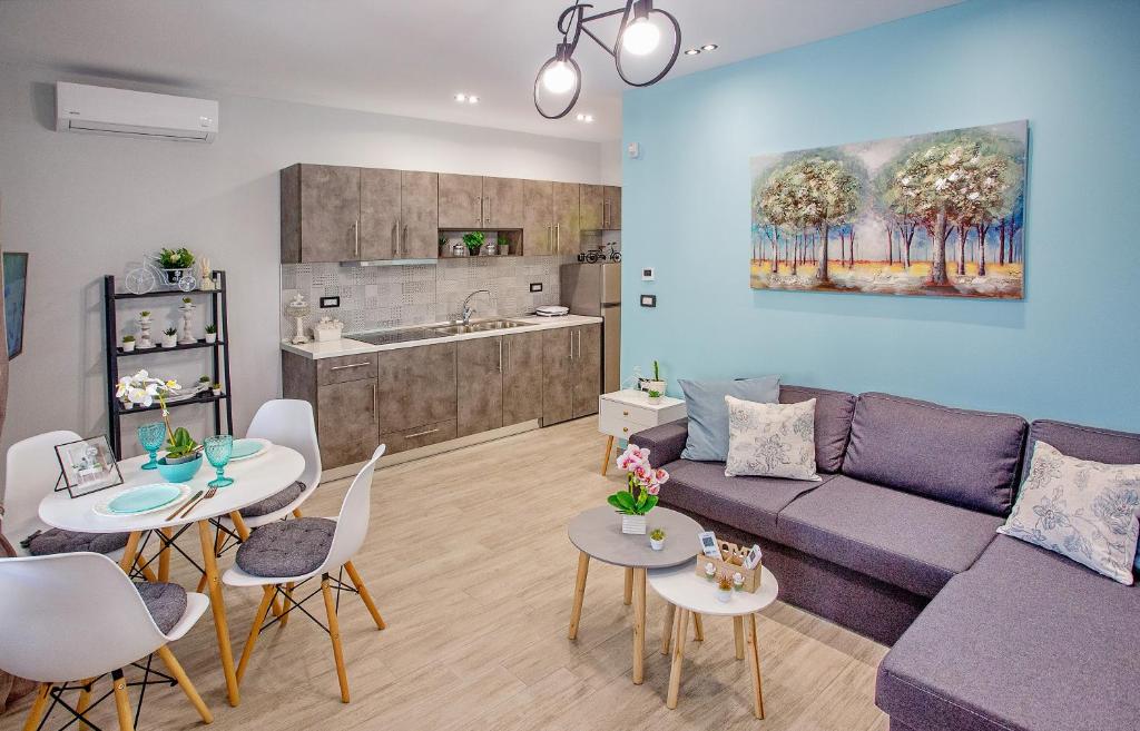 uma sala de estar com um sofá e mesas e uma cozinha em Happy mini suites em Nea Peramos