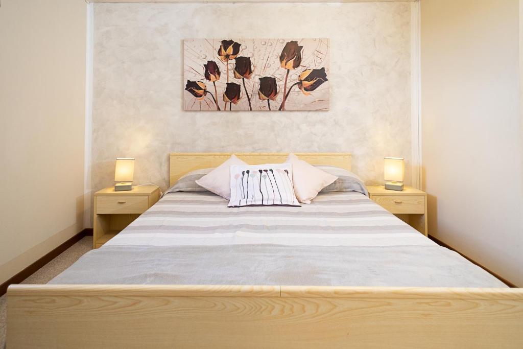 una camera da letto con un grande letto con due comodini di RUSTICO PARK DELLE ROSE - Regarda Travel a Lazise