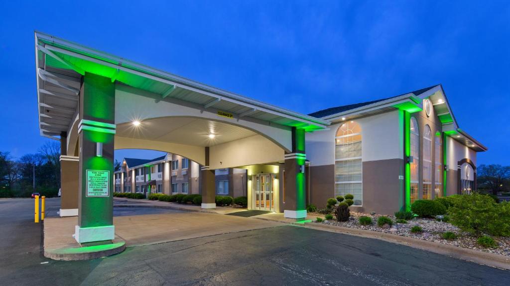 a gas station with green columns in a parking lot at Best Western Airport Inn in Moline