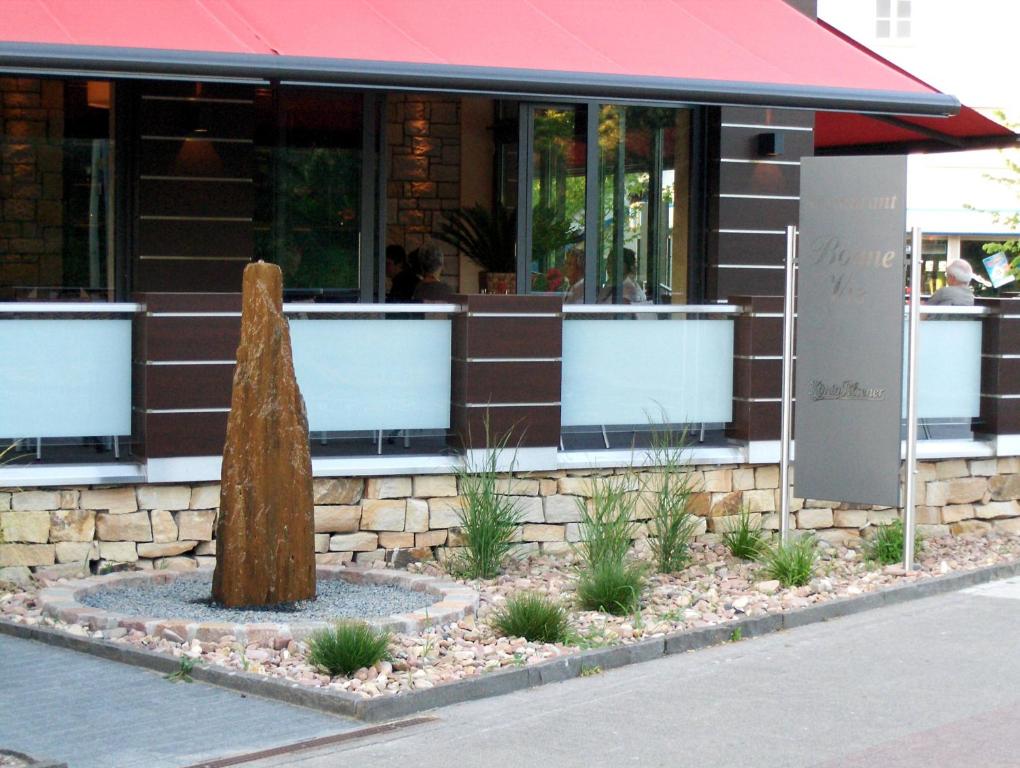 a building with a tree stump in front of it at Hotel Lindenkrug in Gütersloh