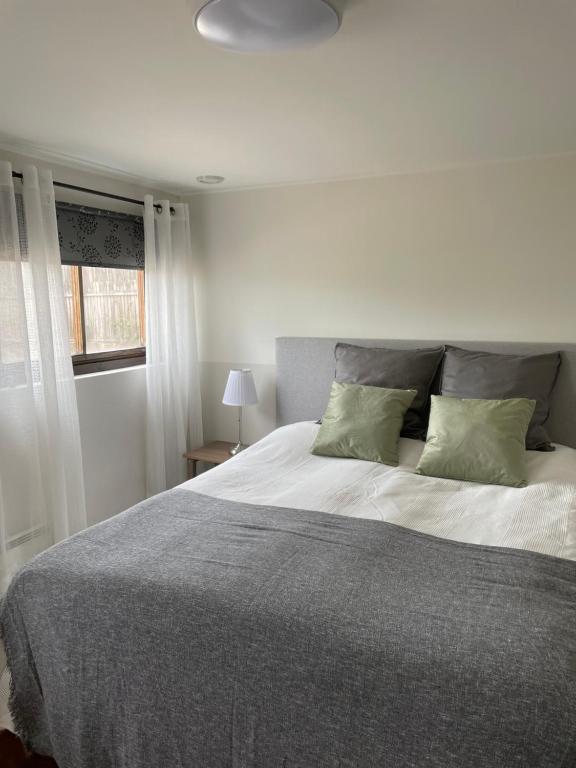 um quarto com uma cama grande e 2 almofadas verdes em Hults-Boaryd Golf och B&B em Hult