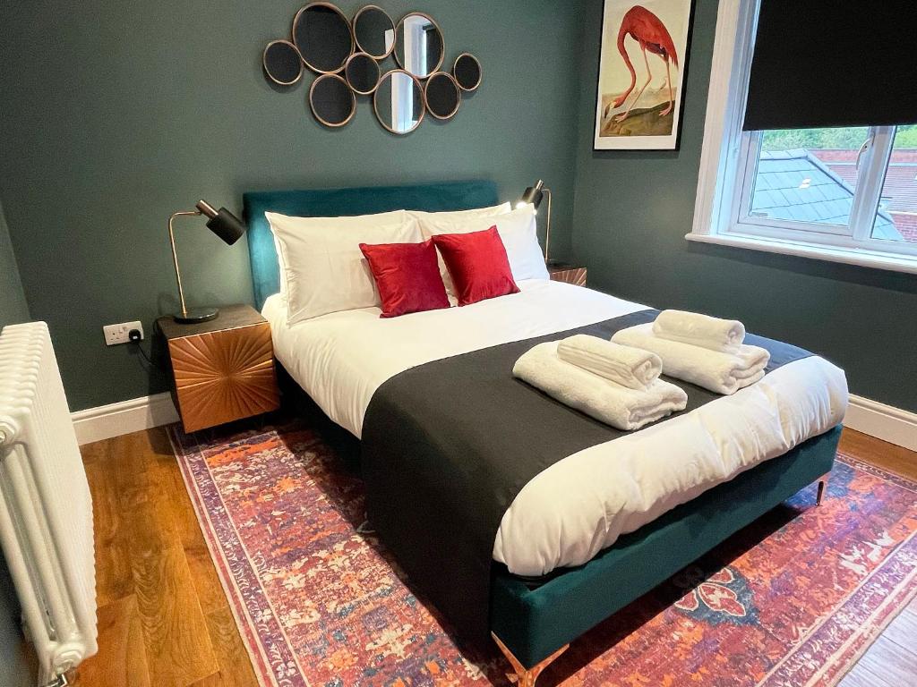 a bedroom with a large bed with red pillows at Apartment 'Boho' in Yeovil