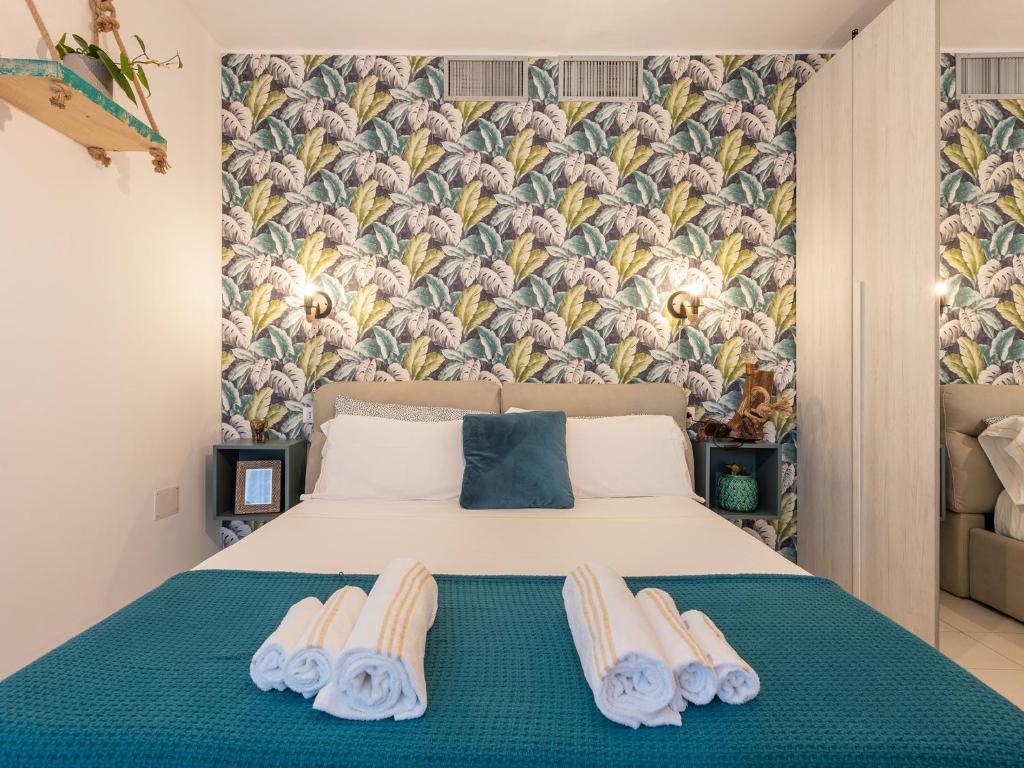 - une chambre avec un lit et des serviettes dans l'établissement Villa Vaghi Rooms, à Cagliari