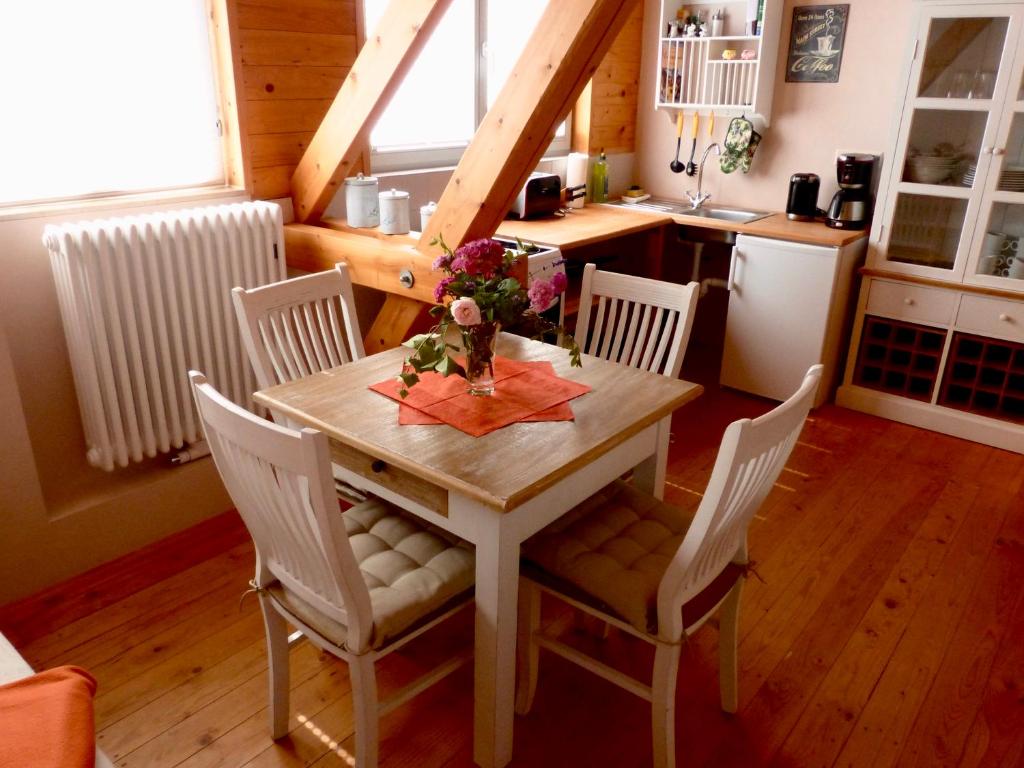 a kitchen with a table and chairs and a kitchen with a refrigerator at Ferienwohnungen Jowatzky Altkötzschenbroda in Radebeul