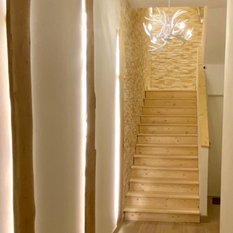 a staircase with a stone wall and a chandelier at wohlBfinden appartementhaus in Braunlage