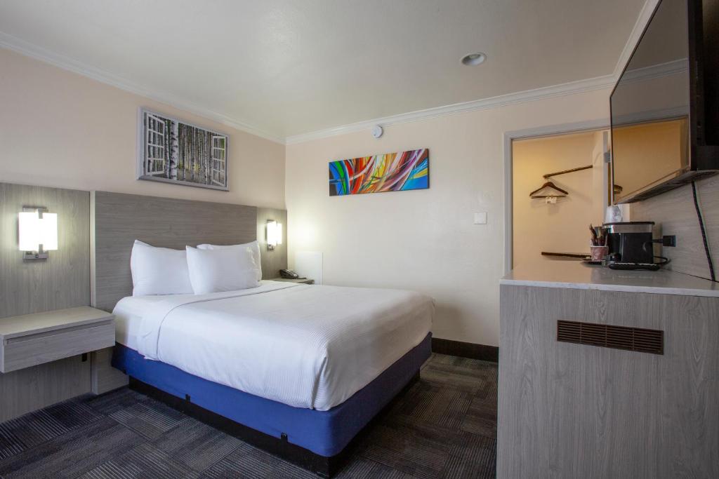 a hotel room with a large bed and a kitchen at Hotel Aspen Flagstaff/ Grand Canyon InnSuites in Flagstaff