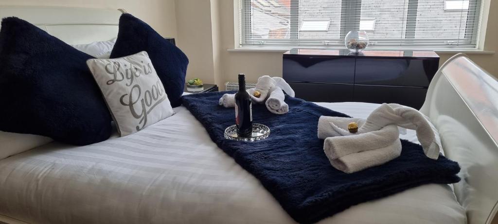 Una cama con un animal de peluche encima. en Elite luxury apartment en Birmingham