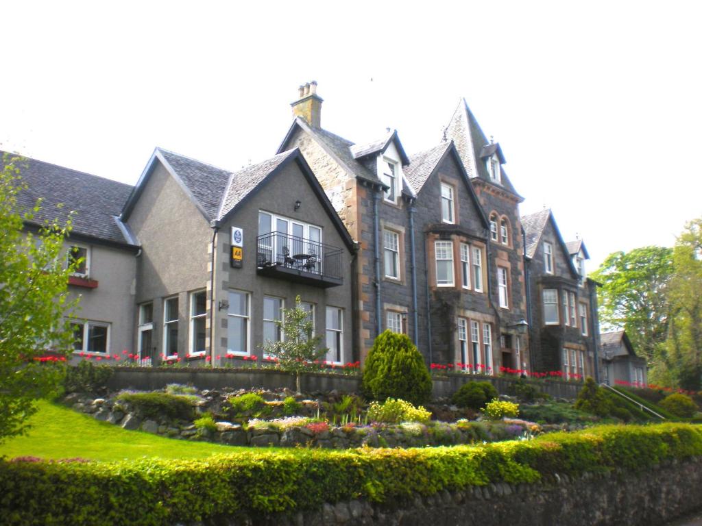 uma casa grande com um jardim em frente em Falls of Lora Hotel em Oban