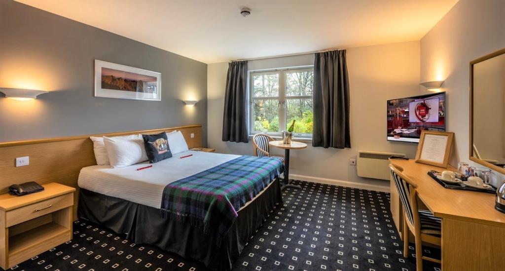 a hotel room with a bed and a desk at Pinehurst Lodge Hotel - Aberdeen in Dyce