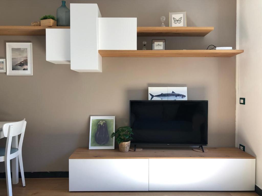 a living room with a television on a white cabinet at La Casa del Principe in Manarola