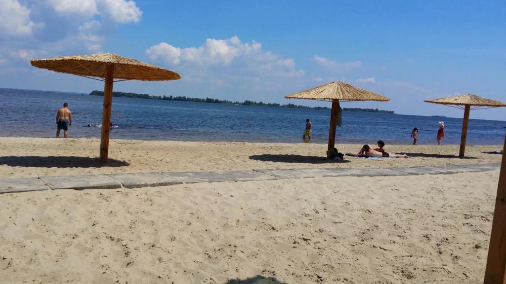 un grupo de personas en una playa con sombrillas en Лучшие апартаменты для размещения с детьми возле Днепра, центр в пешей доступности en Cherkasy
