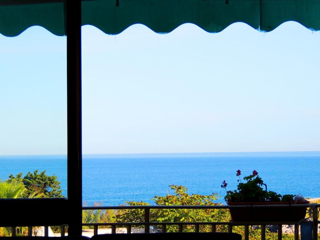 uma vista para o oceano a partir de uma varanda do hotel em Hotel Porto Badisco em Porto Badisco
