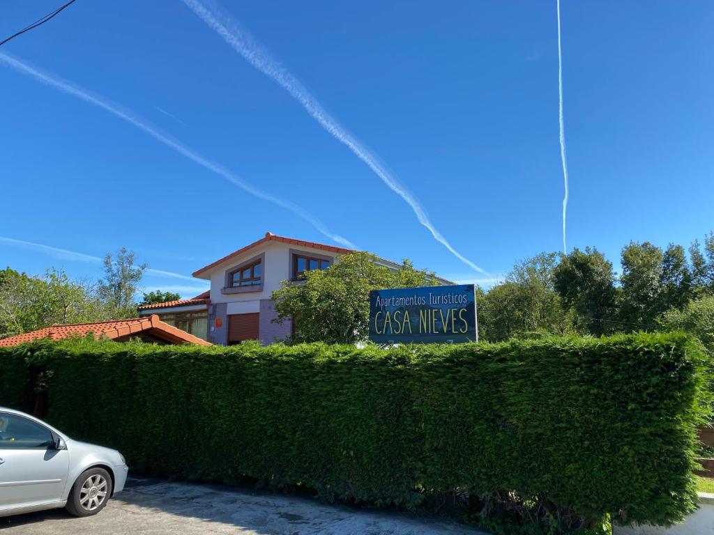 a sign on a hedge in front of a house at Apartamentos Turísticos Casa Nieves in La Franca