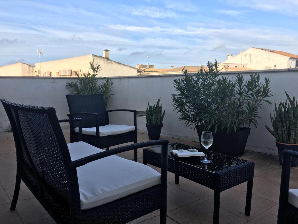 a patio with chairs and a table with a glass of wine at Casa de pueblo amplia in Sa Pobla