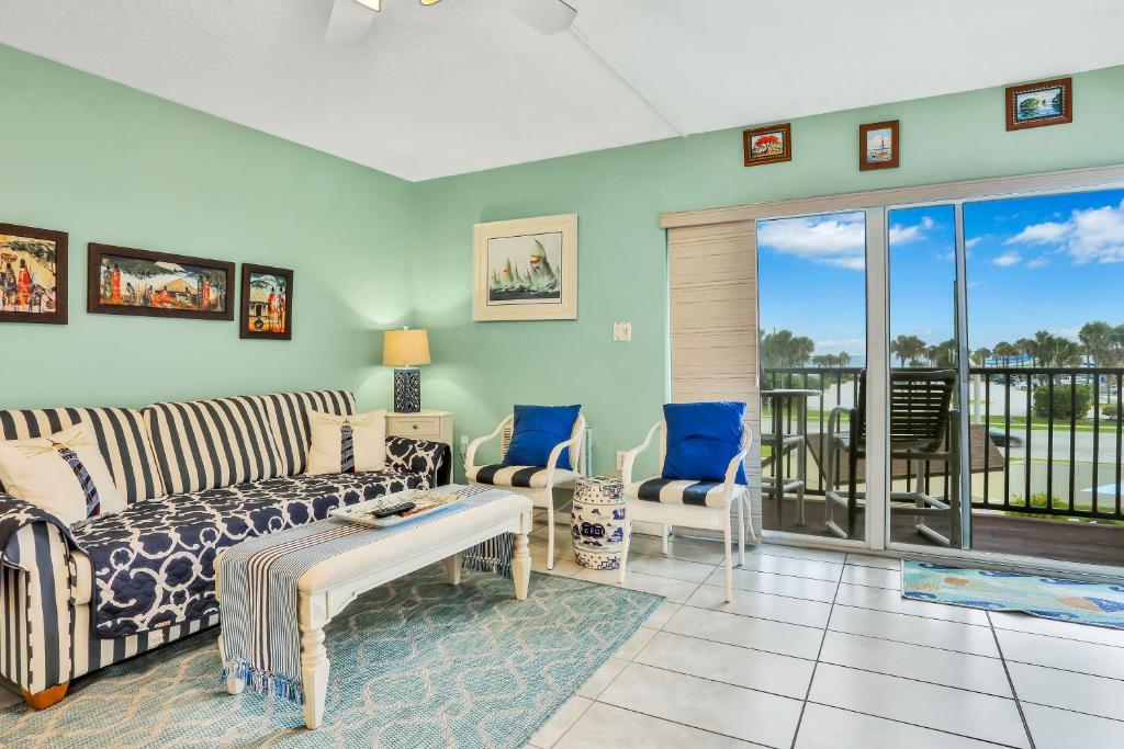 sala de estar con sofá y sillas en Mariners Cove 302, en New Smyrna Beach