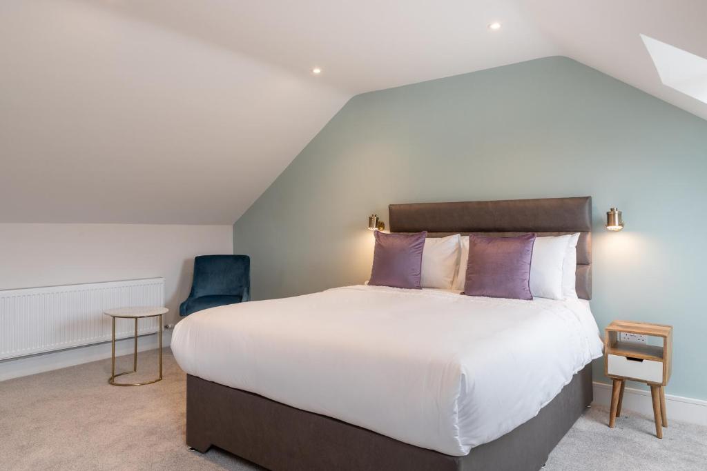 a bedroom with a large bed with purple pillows at The Hawthorn Rooms Dingle in Dingle