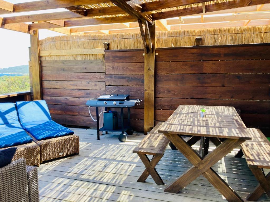 a room with a table and a desk on a deck at Appartement Cemiliana in Bonifacio