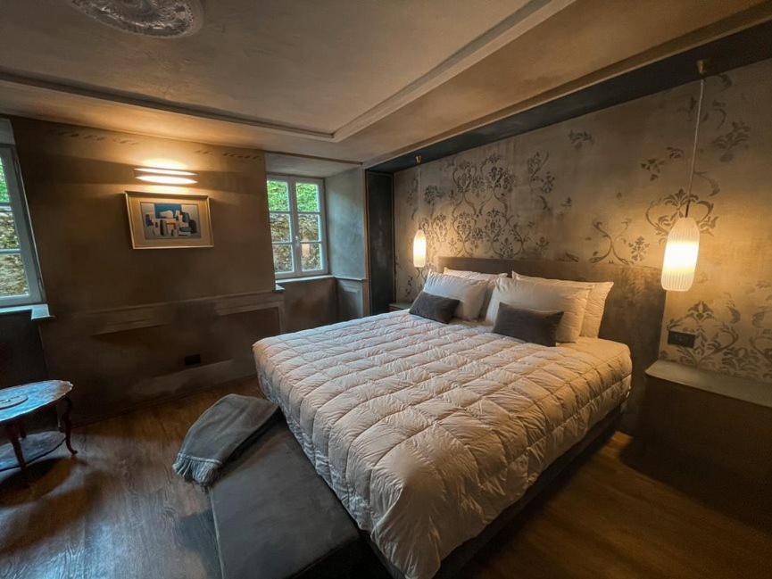 a bedroom with a large bed and two windows at DIMORA SCURONE in Cannobio