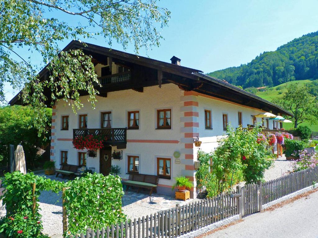 uma casa grande com uma cerca em frente em Ferienwohnungen Meyerlhof em Aschau im Chiemgau