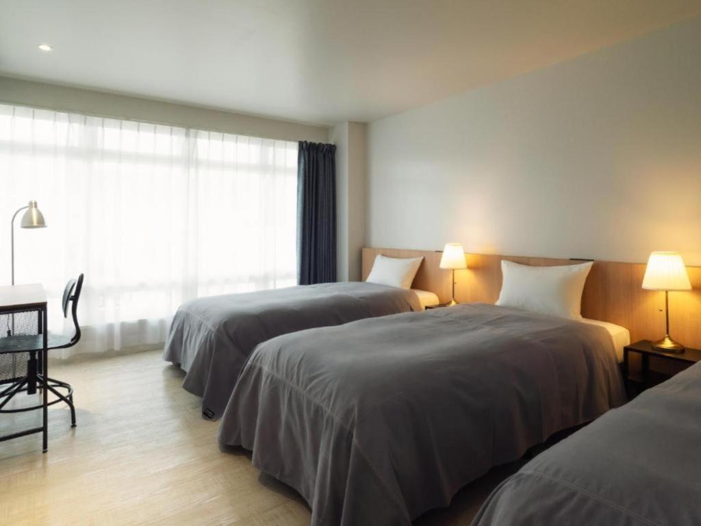 a hotel room with two beds and a window at SHIRAHAMA KEY TERRACE SEAMORE RESIDENCE - Vacation STAY 35168v in Kanayama