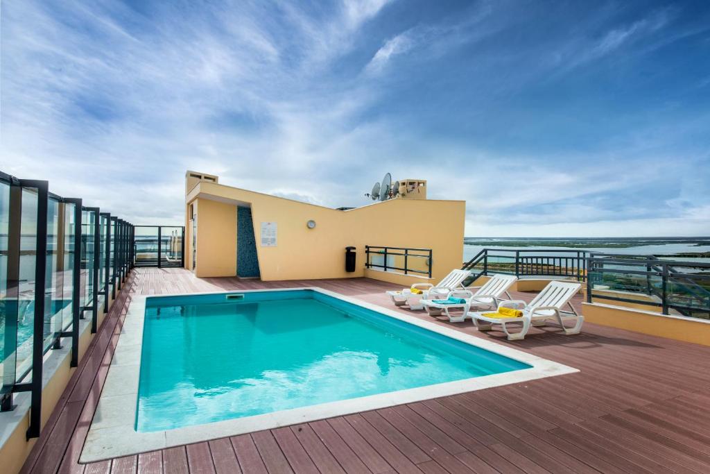 a swimming pool on the balcony of a house at Apartamento Marina Olhão in Olhão