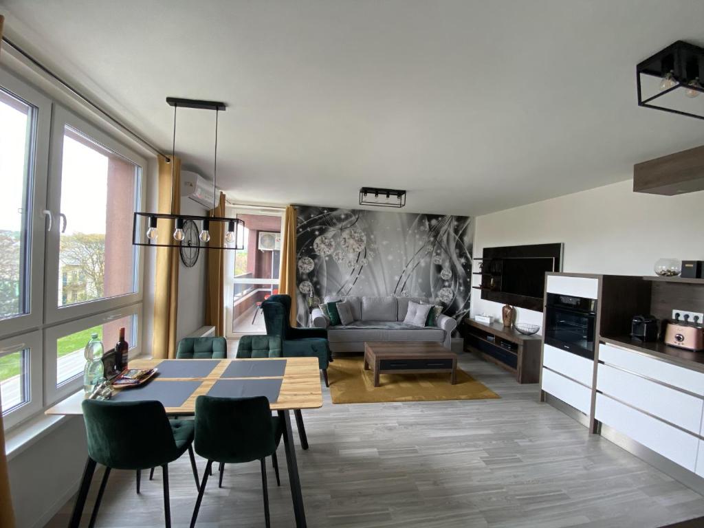 ein Wohnzimmer mit einem Tisch und grünen Stühlen in der Unterkunft GNG Apartment in Košice