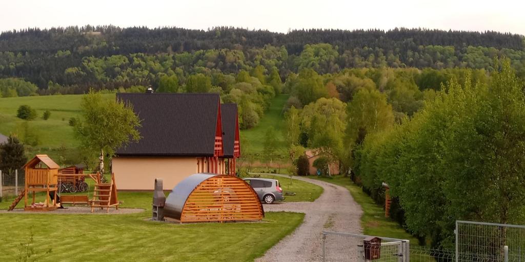 a house with a hobbit house next to a road at Domki Brzozówka w Bieszczadach in Ustrzyki Dolne