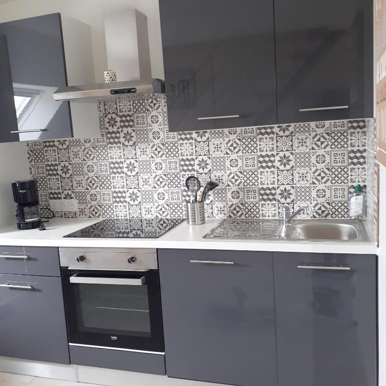 une cuisine avec un évier et un plan de travail dans l'établissement Appartement à la campagne, à Noyal-Muzillac