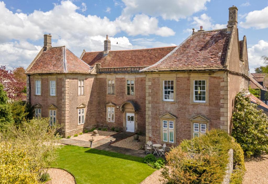 an old brick house with a garden in front of it at The Old Parsonage in Farrington Gurney