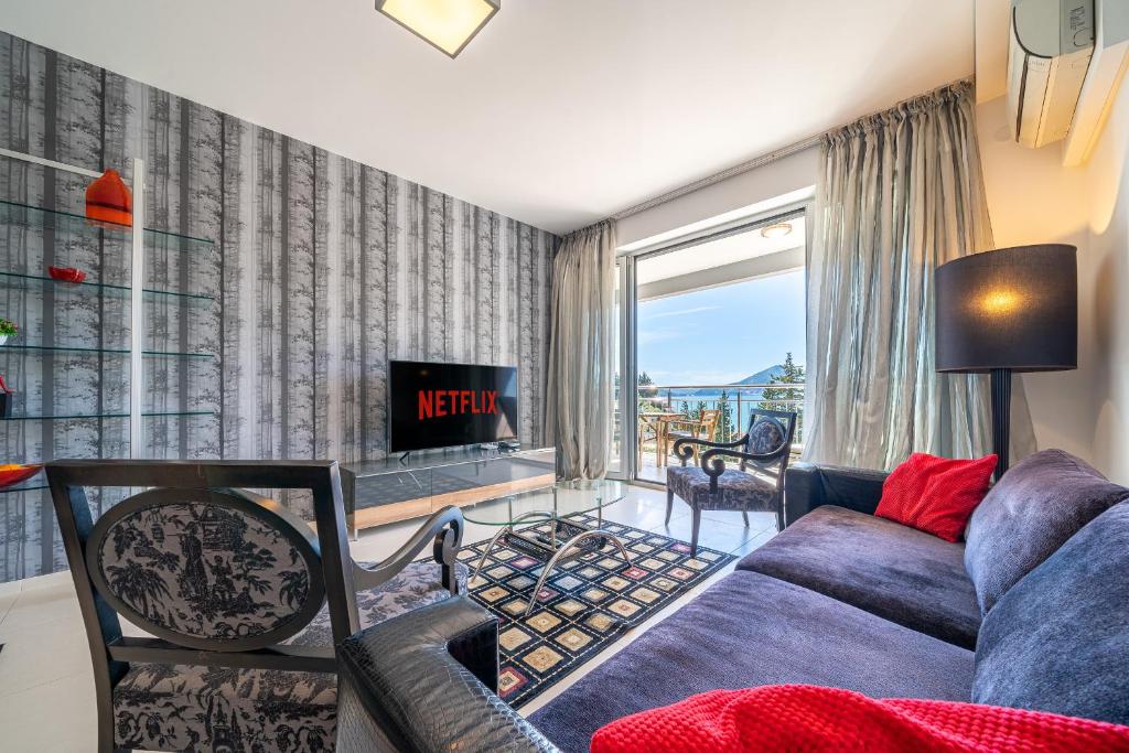 a living room with a couch and a tv at Apartment Sweet Memories in Sveti Stefan