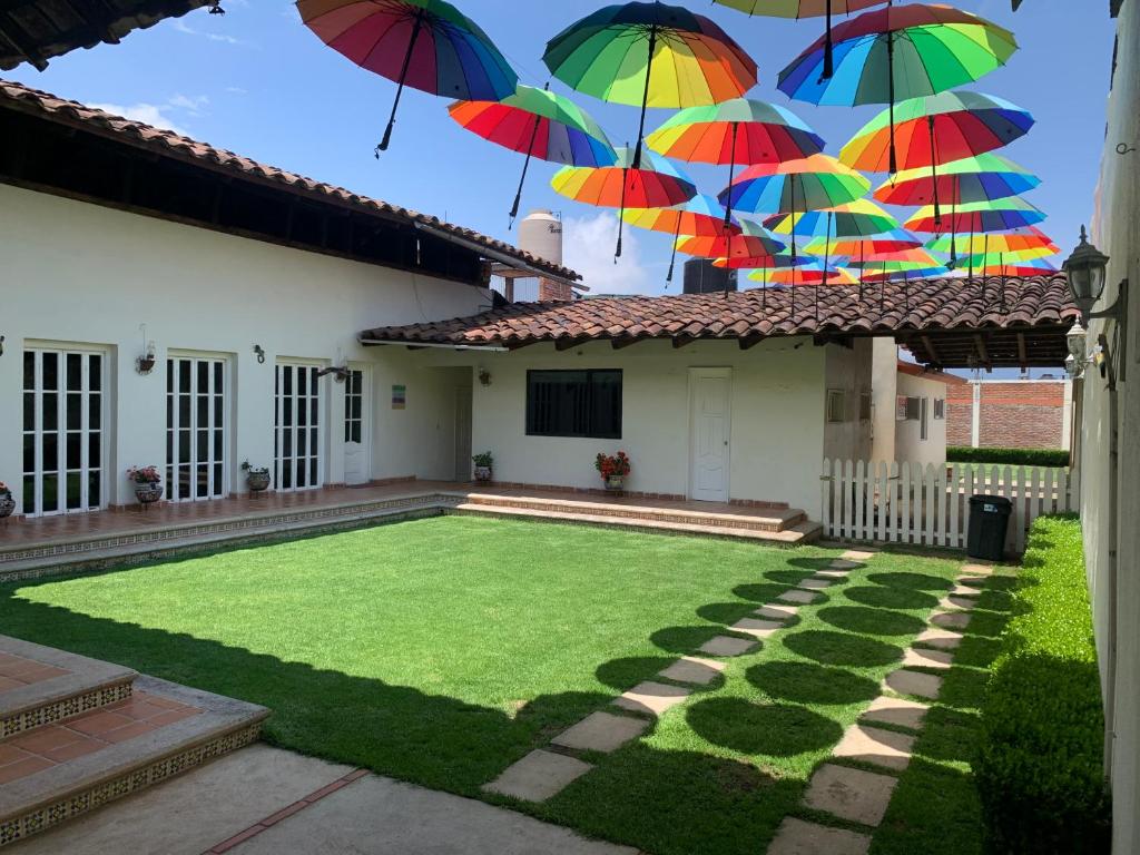 a yard with umbrellas hanging from a house at CASA SÁNCHEZ in Zacatlán