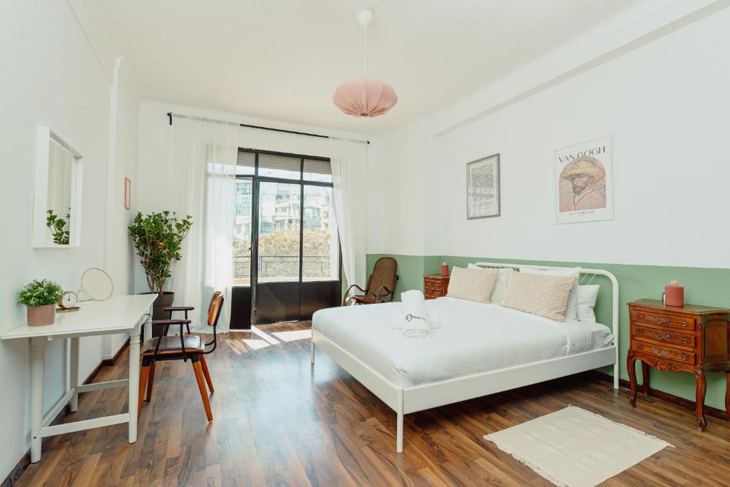 een woonkamer met een wit bed en een bureau bij Appartements - Centre Ville in Rabat