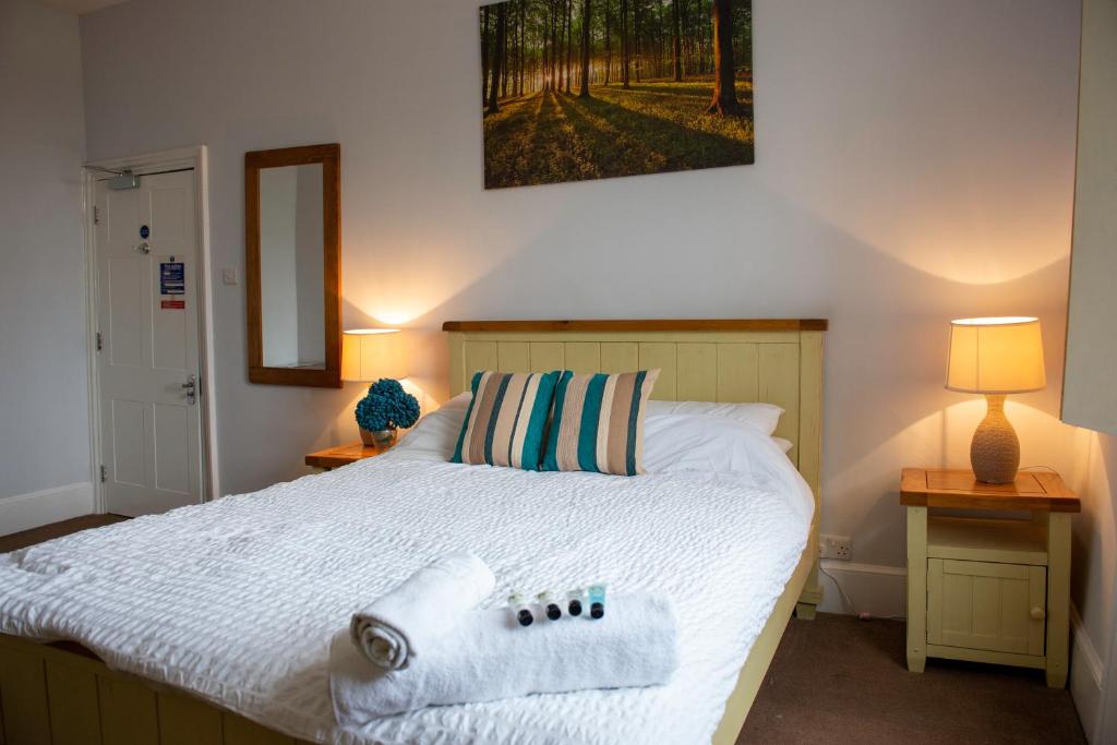 sypialnia z łóżkiem z ręcznikami w obiekcie The Vale Hotel w mieście Cricklade