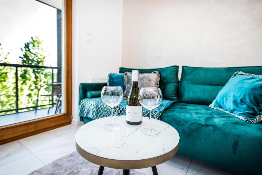a wine bottle and two wine glasses on a table at GDAŃSK blisko MORZA nowy Apartament in Gdańsk