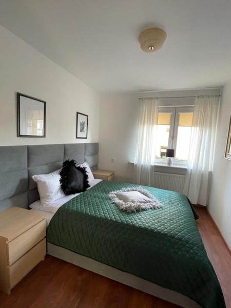 a bedroom with a green bed and a window at Apartament 3 pokojowy Międzyzdoje 55m2 - 200 metrów od morza in Międzyzdroje