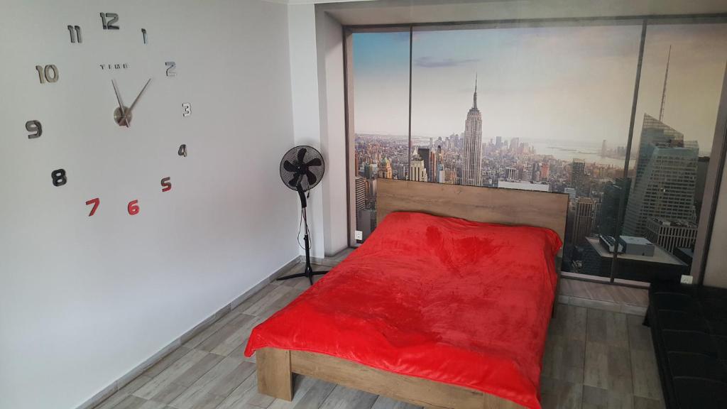 ハイドゥソボスローにあるIllaberek apartmanokのベッドルーム1室(窓の前に赤いベッド1台付)