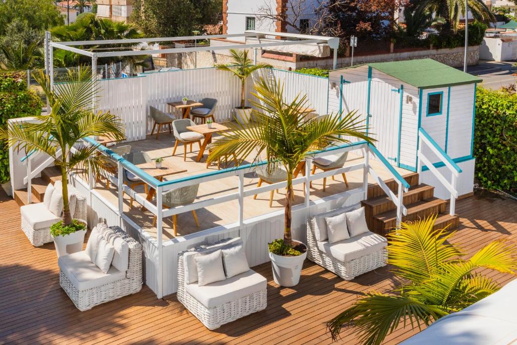 eine Terrasse mit Stühlen und ein kleines Haus in der Unterkunft Antonio's House in Sitges