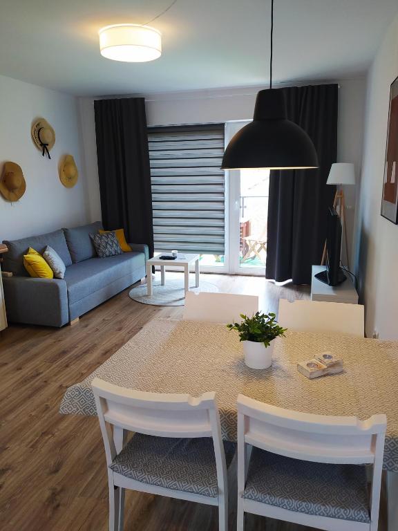 a living room with a table and a couch at M&K Apartament Słomkowe Kapelusze - Sobieszewo, Wyspa Sobieszewska in Gdańsk