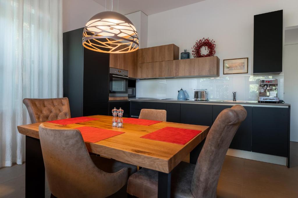 uma cozinha com uma mesa de madeira com cadeiras à volta em Luxury Apartments Portoroz em Portorož