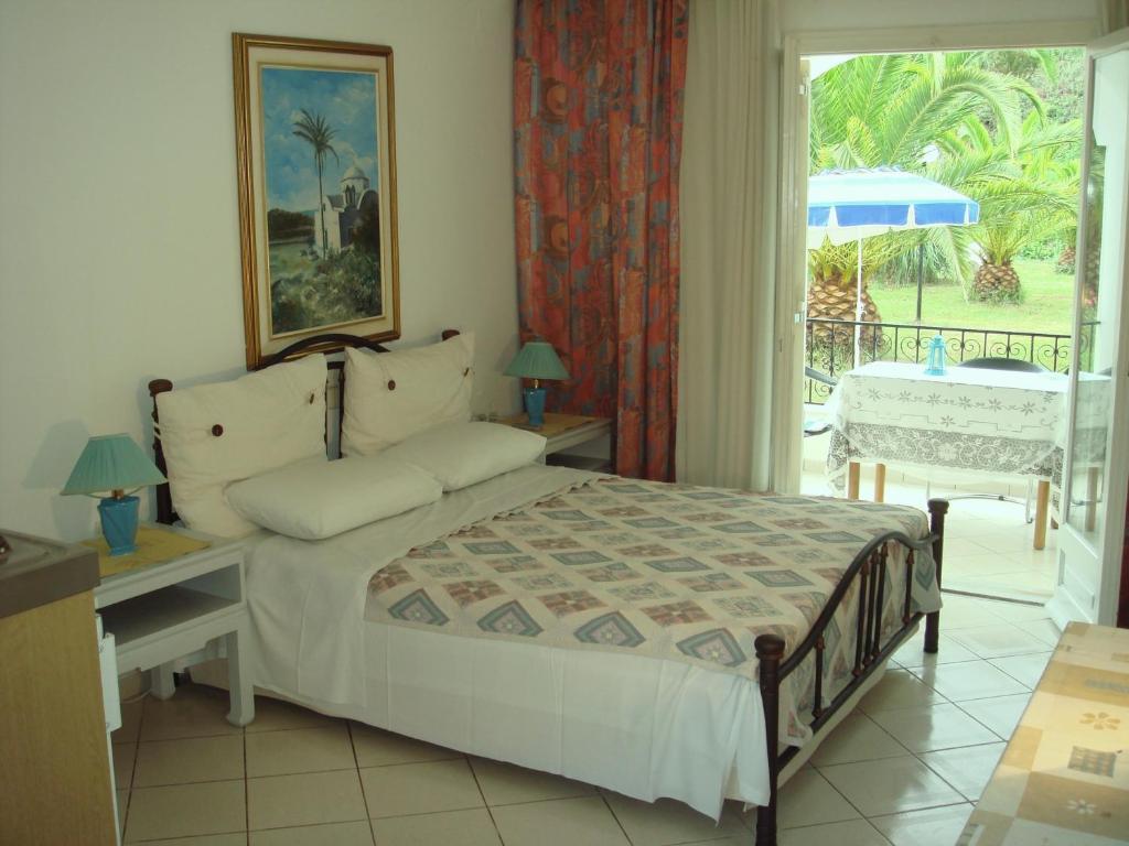 a bedroom with a bed and a table with an umbrella at Alessandro in Sidari