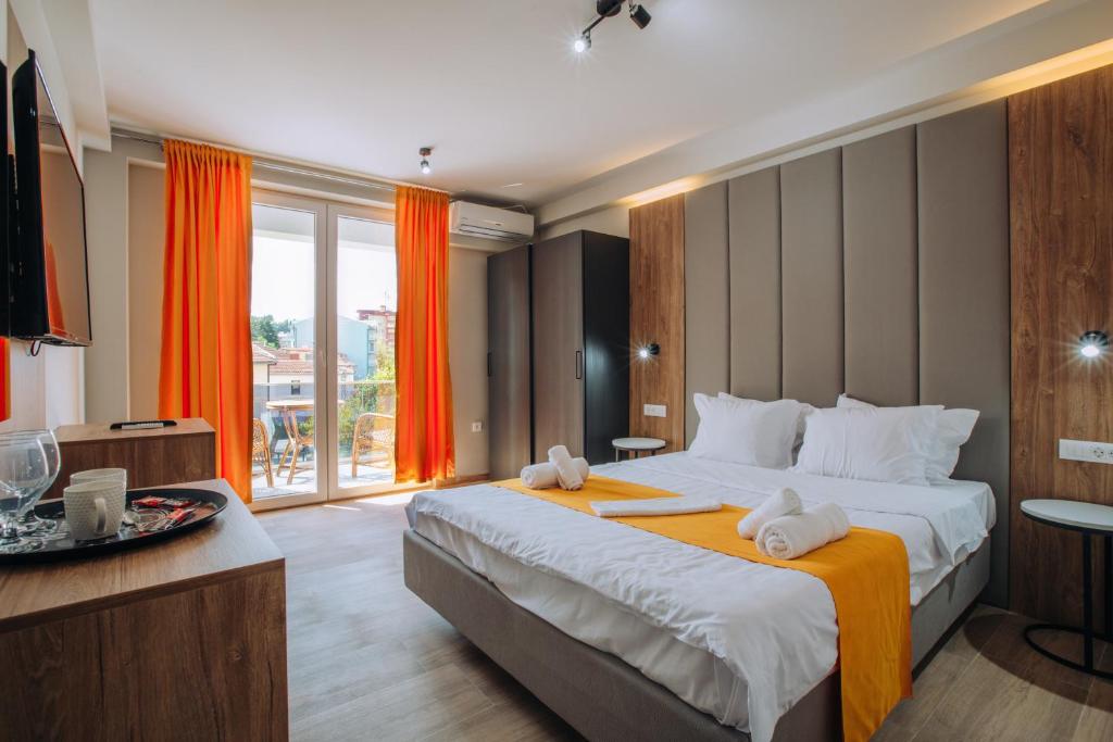 a hotel room with a large bed with orange curtains at Villa Darki in Ohrid